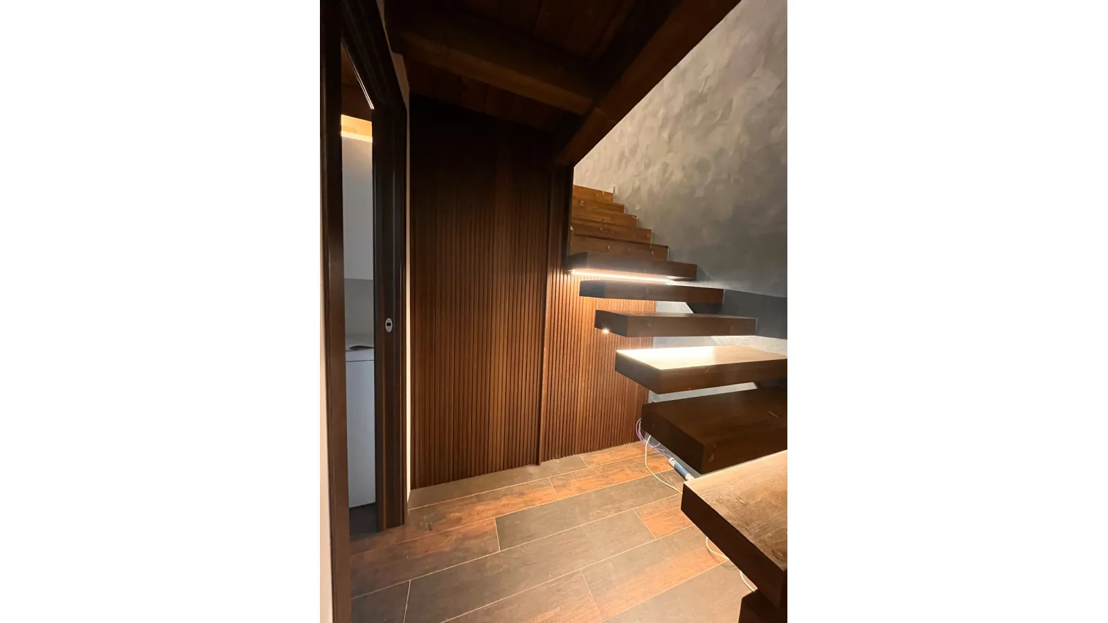 Porta a scomparsa con boiserie in legno a listelli verticali